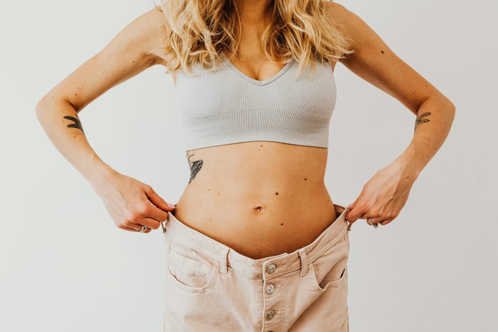 Woman holding up pants from weight loss